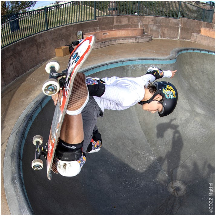 male skating a bowl wearing hot wheels helmet and padding 