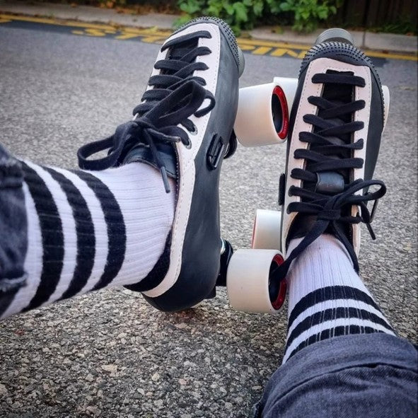 person wearing black and white roller skate speed 