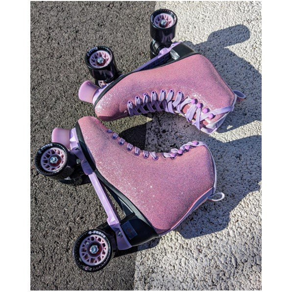 pink glitter high top roller skates laid on road 