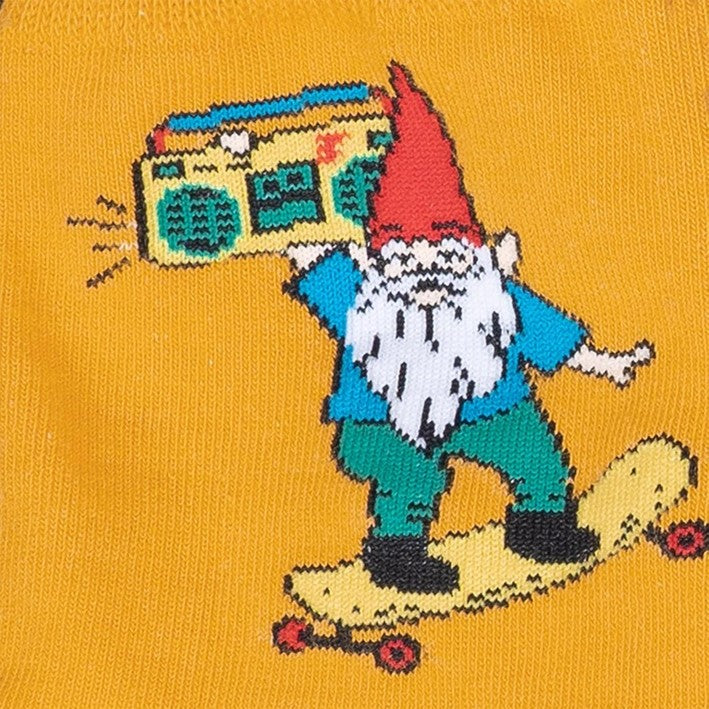 CLOSE UP OF MUSTARD YELLOW CREW SOCKS WITH PATTERN OF GNOME SKATEBOARDING WITH BOOMBOX