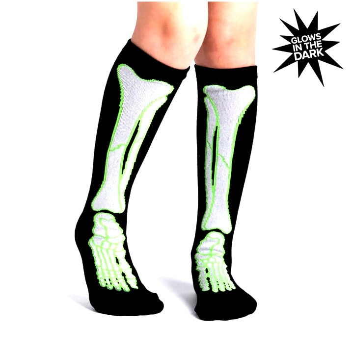 KID WEARING BLACK KNEE HIGH SOCKS WITH WHITE AND GREEN GLOW IN THE DARK SKELETON PRINT