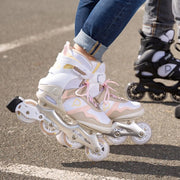 PERSON WEARING WHITE INLINE SKATES WITH BROWN AND PEACH 