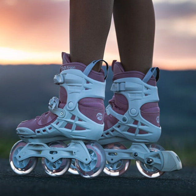 pink 3 wheeled inlione skates with white frames and white brake 