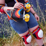 person wearing s1 retro knee and elbow pad holding rainbow roller skate