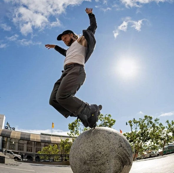 MAN JUMPING OVER CONCRETE BALL WEARING ROLLERBLADE XT INLINE SKATES 