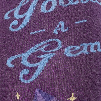 CLOSE UP OF TEXT "YOURE A GEM" ON PURPLE GLITTER SOCK