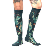 PERSON WEARING KNEE HIGH DARK GREEN SOCKS WITH CACTUS PATTERN