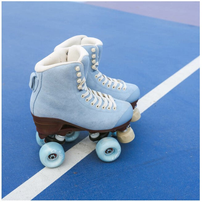 chaya baby blue suede high top rollerskates with brown sole and blue 'cloud 9' outdoor wheels cream adjustable toe stop on basketball court