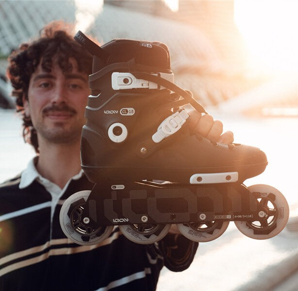 Person holding a pair of black inline skates with wheels visible - Lucky Skates 