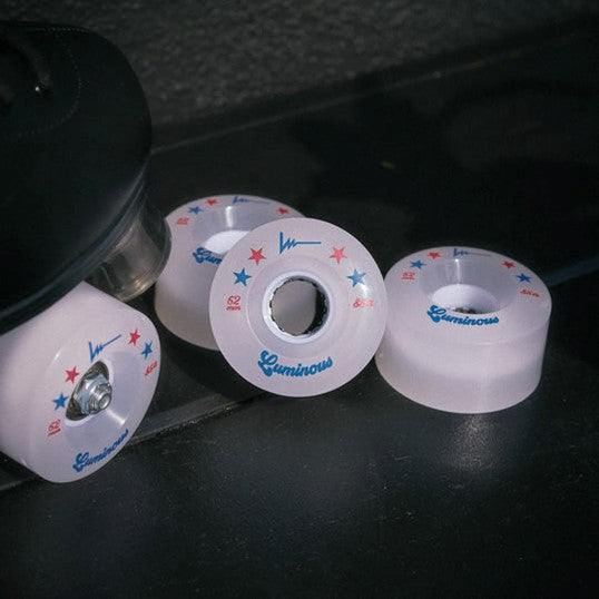 4 pack of white led luminous roller skate wheels next to a roller skate