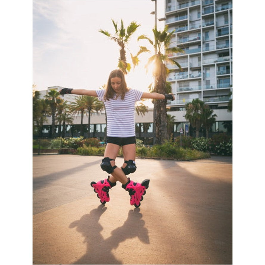 GIRL DOING TRICK ON HOT PINK AND BLACK INLINE SKATES 