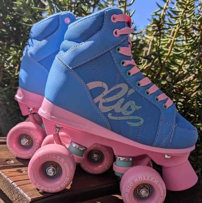 blue pink sneaker style mid top rollerkskate boot, pink wheels and plate, 'Rio' on side with teal pink ombre,  pink stopper