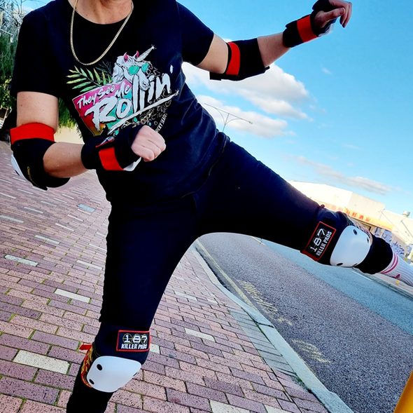 girl doing a high kick in 187 killer black knee pads elbow pads and wrist guards