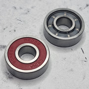 front and back of red shielded skate bearing