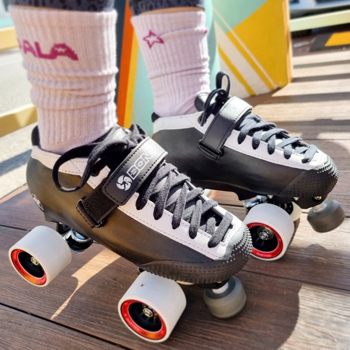 person wearing black and white skate rollerskates 