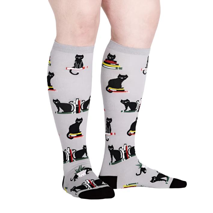 PERSON WEARING KNEE HIGH GREY SOCKS WITH BLACK CATS AND BOOKS PATTERN