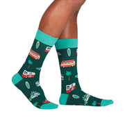 PERSON WEARING DARK GREEN CREW SOCKS WITH PATTERN OF TRAVELLING CARS PALM TREES SURFBOARDS