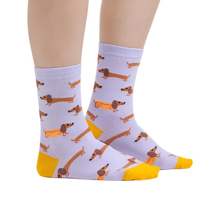 PERSON WEARING LILAC CREW SOCKS WITH YELLOW HEEL AND TOE WITH PATTERN OF SAUSAGE DOGS