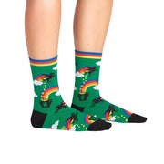 PERSON WEARING GREEN CREW SOCKS WITH MAGICAL UNICORNS AND LUCKY POT AT END OF RAINBOW