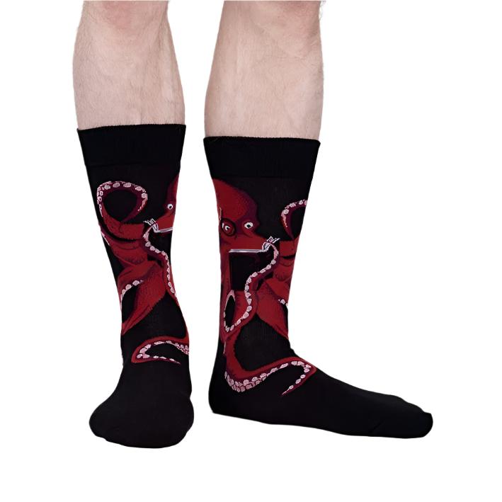 PERSON WEARING BLACK CREW SOCKS WITH RED OCTOPUS READING A BOOK