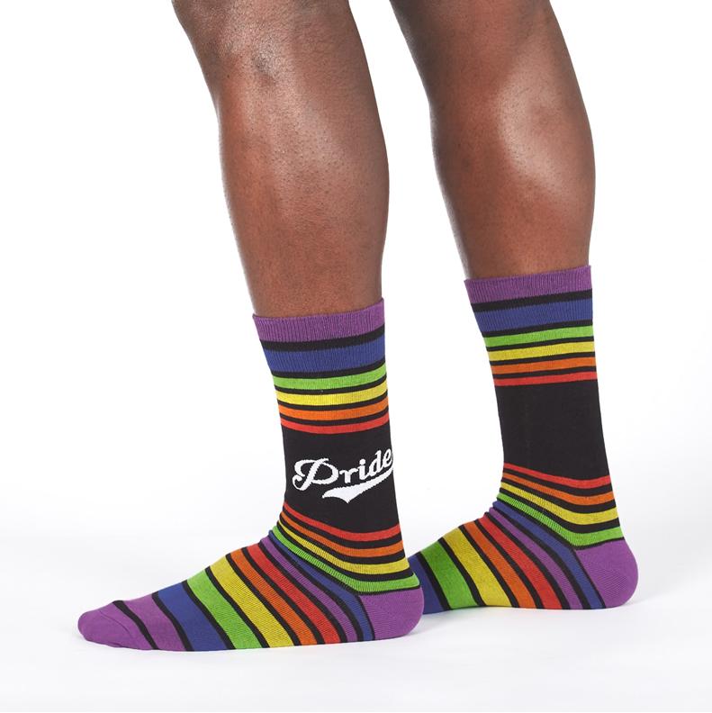 PERSON WEARING RAINBOW STRIPE CREW SOCKS WITH TEXT "PRIDE"