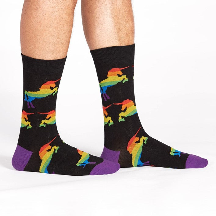 PERSON WEARING BLACK AND PURPLE CREW SOCKS WITH RAINBOW UNICORN PATTERN