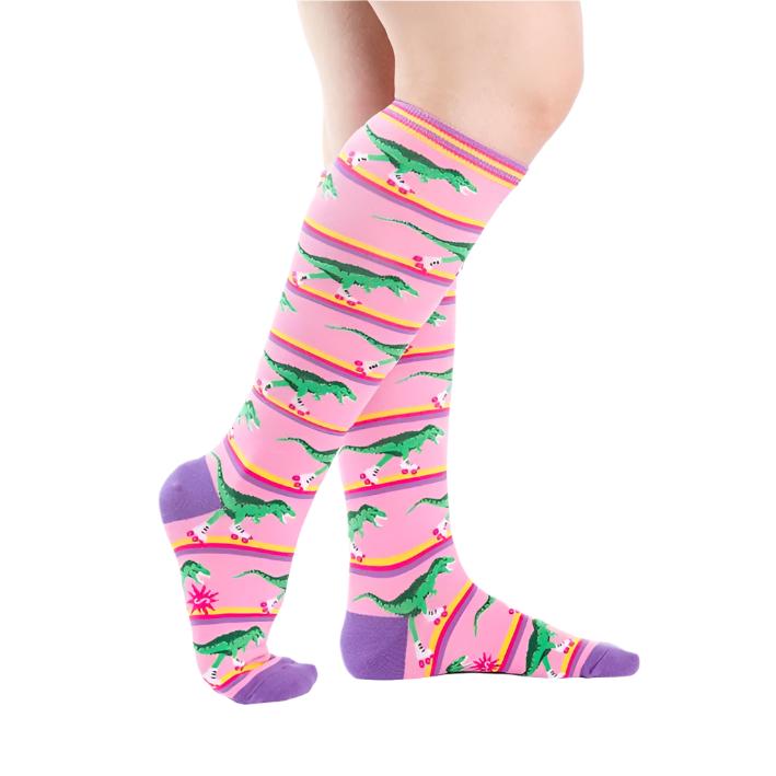 person weaing pink knee high socks with dinosaurs roller skating