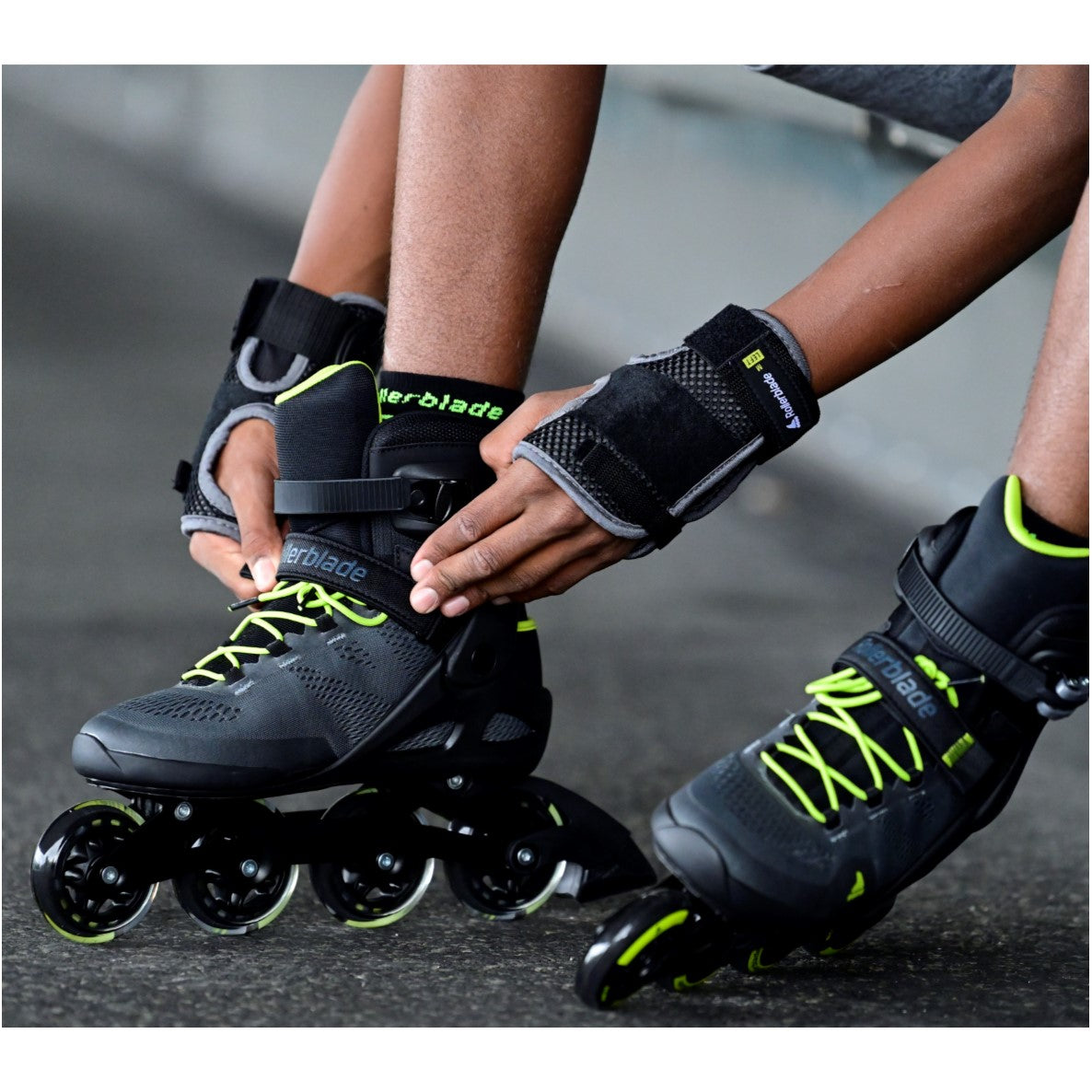 PERSON WEARING BLACK GREEN ROLLERBLADES