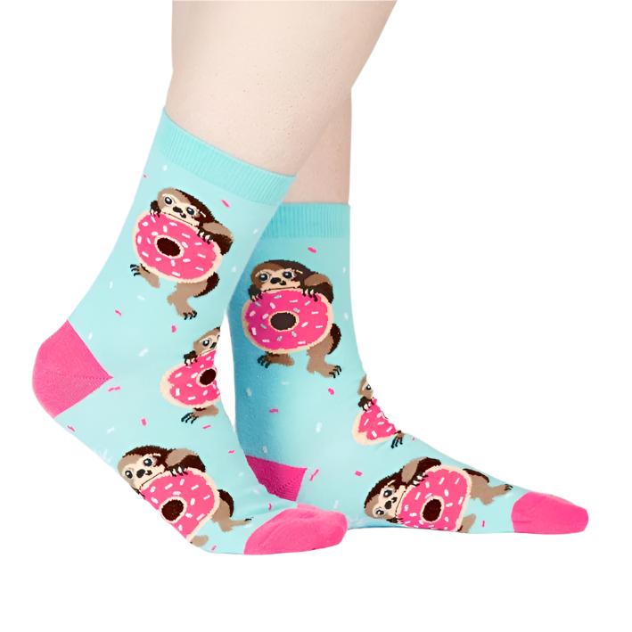 PERSON WEARING LIGHT BLUE CREW SOCK WITH SLOTH HOLDING PINK DONUTS