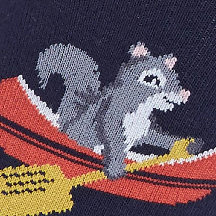 CLOSE UP OF NAVY BLUE SOCK WITH SQUIRREL SITTING IN RED BOAT WITH PADDLE