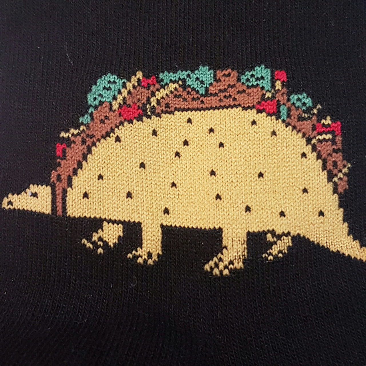 CLOSE UP OF TACO DINOSAUR ON BLACK SOCK