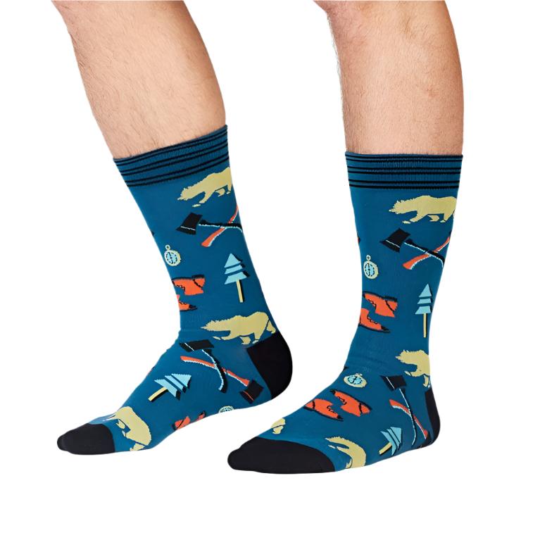 PERSON WEARING BLUE CREW SOCKS WOTH PATTERN OF BEARS AND SURVIVAL FORREST TOOLS