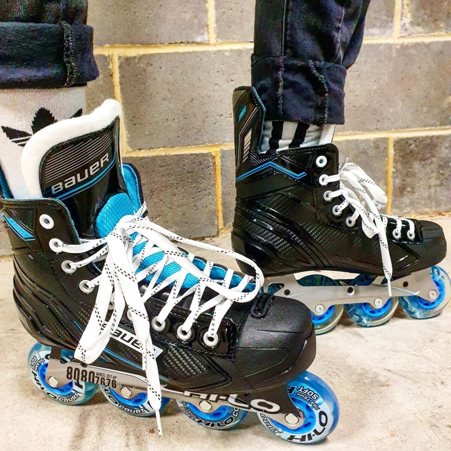 person wearing bauer rsx skates blue wheels