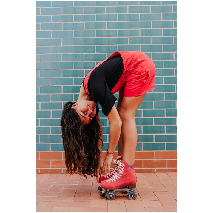 GIRL WEARING RED SUEDE HIGH TOP ROLLER SKATES WITH BLACK WHEELS 