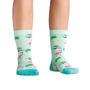 PERSON WEARING MINT GREEN CREW SOCKS WITH PATTERN OF RETRO CARAVANS FLAMINGOS AND PALM TREES