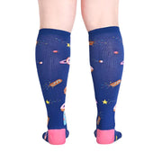 PERSON WEARING DARK BLUE KNEE HIGH SOCKS WITH PATTERN OF DONUTS AS A GALAXY WITH PINK HEEL