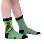 KID WEARING GREEN CREW SOCK WITH T REX ON SIDE