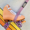 PEACH MOXI SKATE BEING HELD UP WITH PINK GLITTER LUCKY SKATES SKATE STRAP 