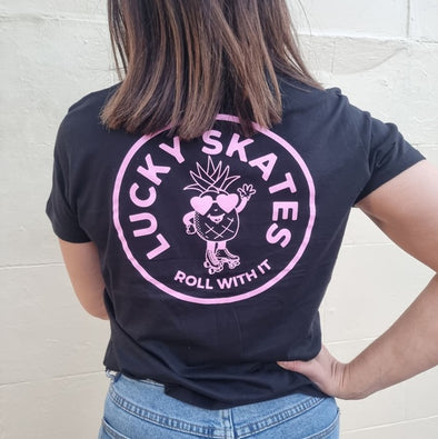 WOMENS BEAROING BLACK TEE WITH PINK LOGO OF PINEAPPLE WEARING ROLLER SKATES lucky skates roll with it 