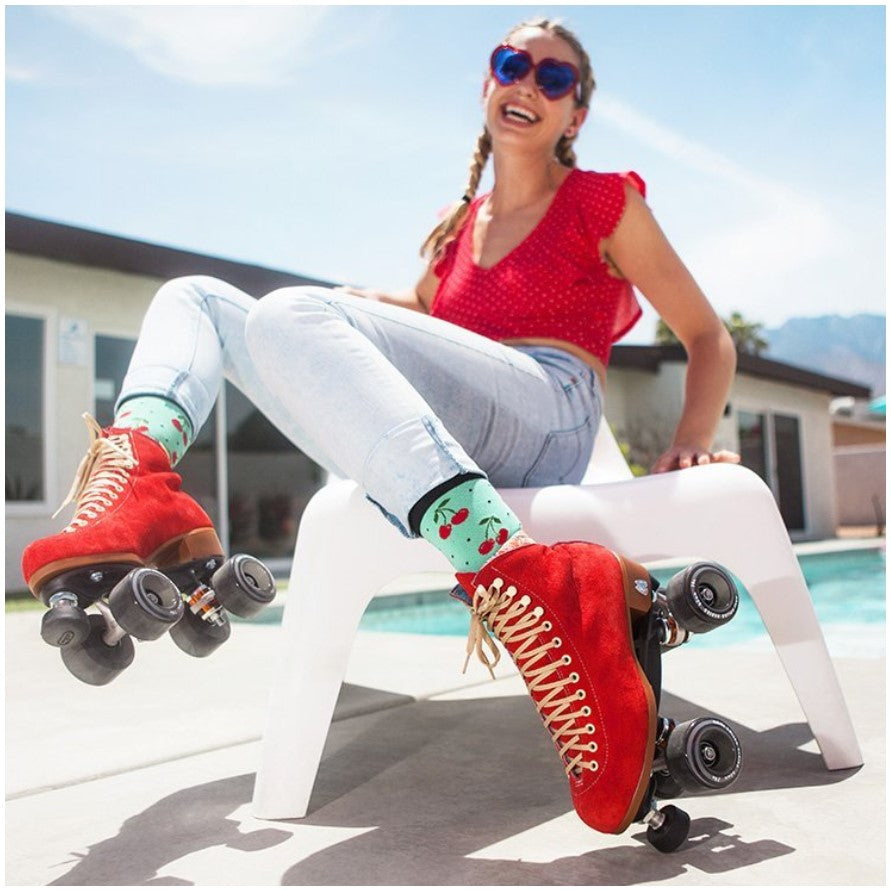 GIRL WEARING RED HIGH TOP SUEDE ROLLERSKATES WITH CLEAR RED WHEELS