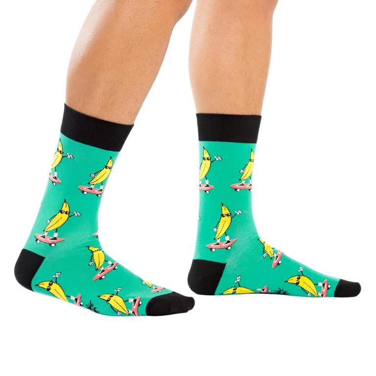 PERSON WEARING BRIGHT GREEN CREW SOCKS WITH PATTERN OF BANANAS RIDING SKATEBOARDS