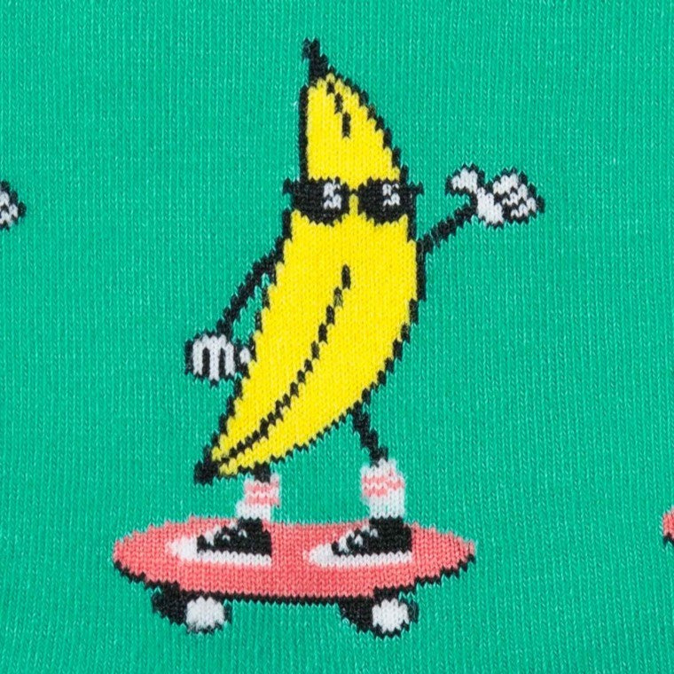 CLOSE UP OF BANANA WEARING SUNNIES ON A SKATEBOARD PATTERN ON GREEN CREW SOCK