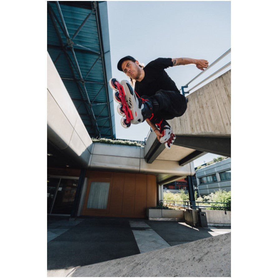 man jumping in grey and red inline skates 