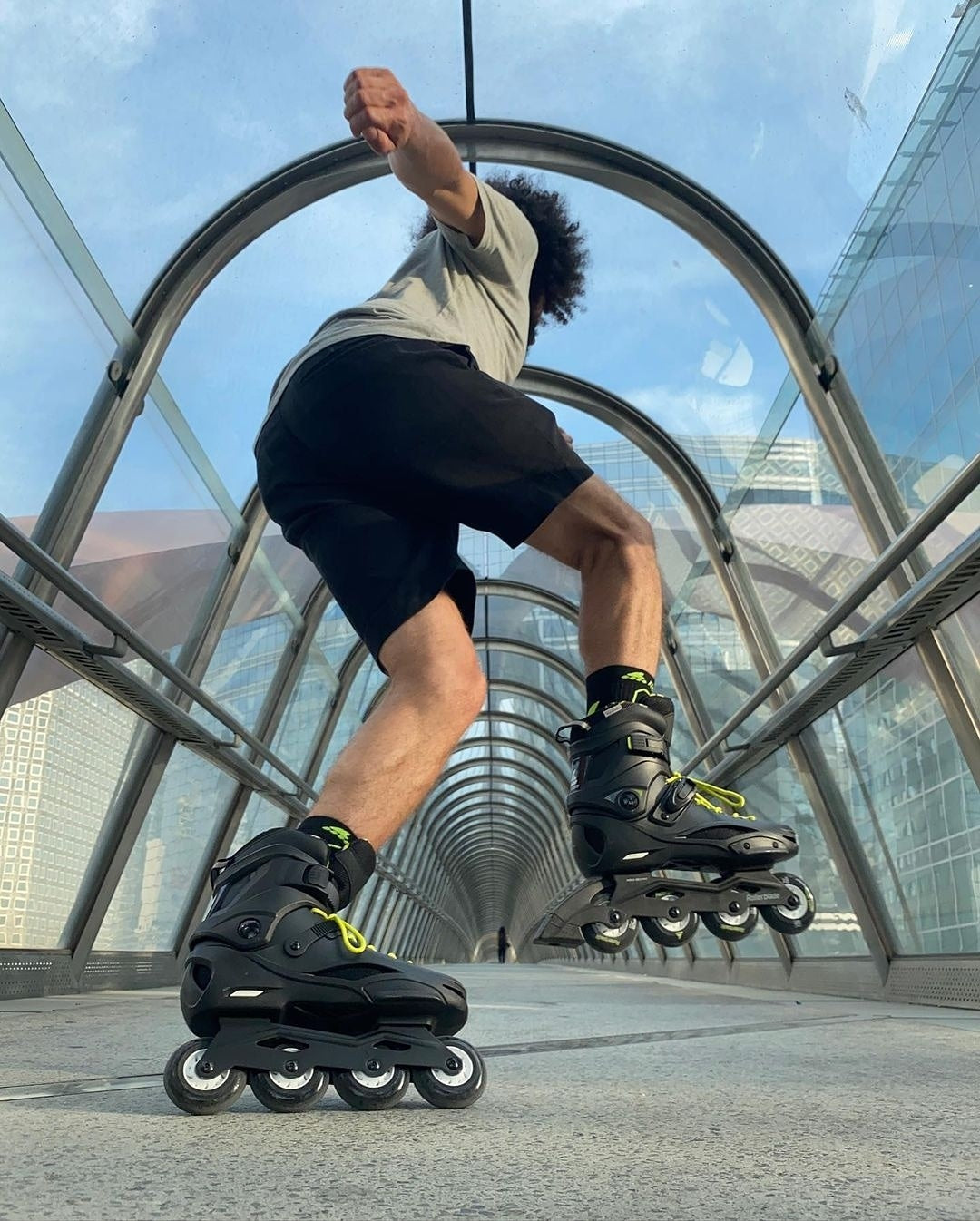 man skating in black yellow rollerblades through tunnel 