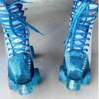 blue roller skates with small disco ball with purple tassels attatched to rollerskate