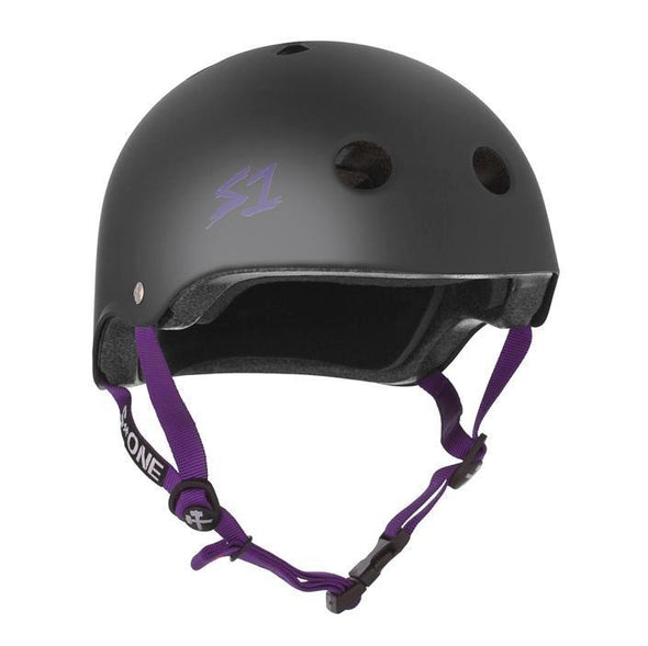 matt black skate helmet with purple straps and text on the side
