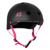 matt black skate helmet with bright pink straps and text on the side