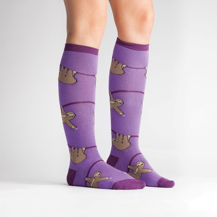 PERSON WEARING PURPLE KNEE HIGH SOCKS WITH PATTERN OF SLOTHS