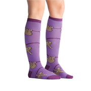 PERSON WEARING PURPLE KNEE HIGH SOCKS WITH PATTERN OF SLOTHS