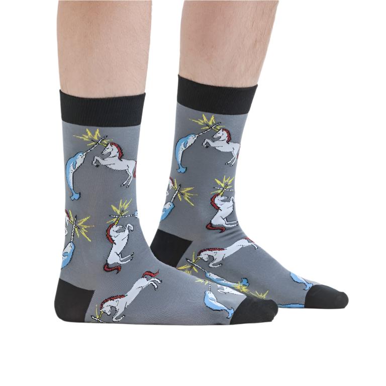 PERSON WEARING GREY CREW SOCKS WITH PATTERN OF UNICORN AND NARWHAL BATTLING